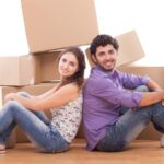 Couple is sitting on the floor in front of moving boxes