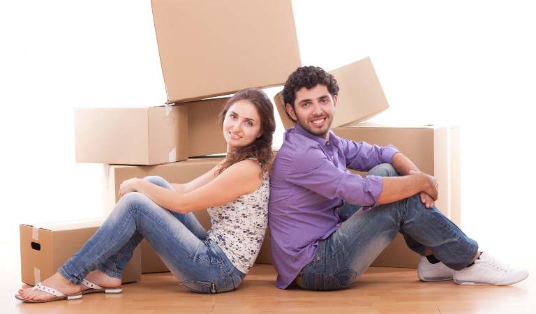 Couple is sitting on the floor in front of moving boxes