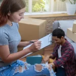 Asian young woman writing the checking of cardoard box