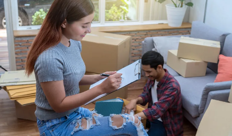 Asian young woman writing the checking of cardoard box